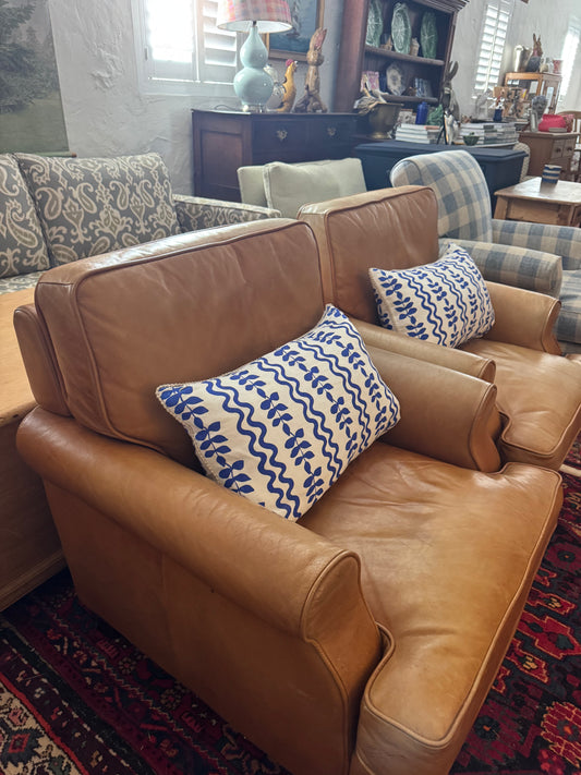 A pair of leather chairs on castors