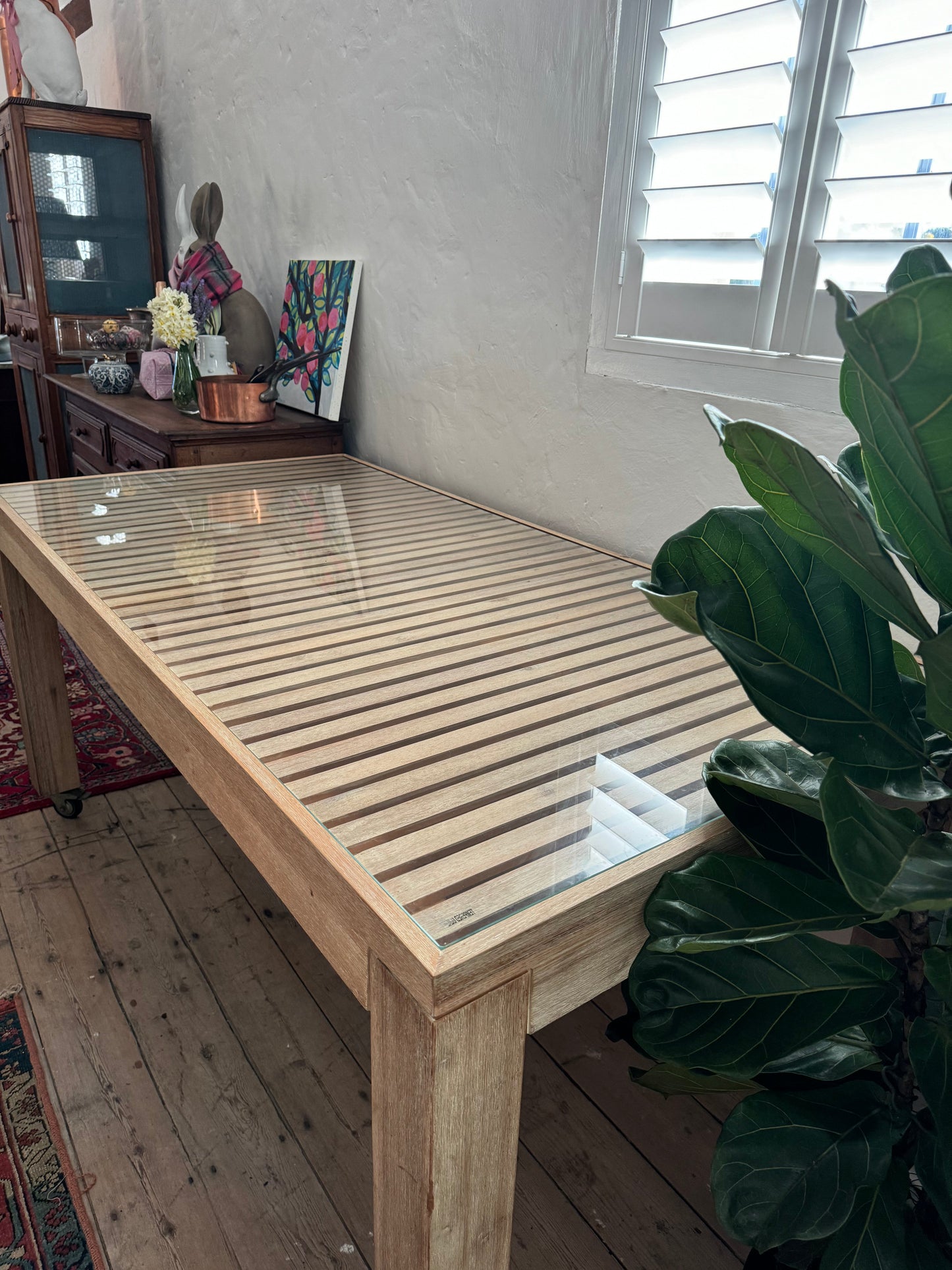 Glass topped table on castors