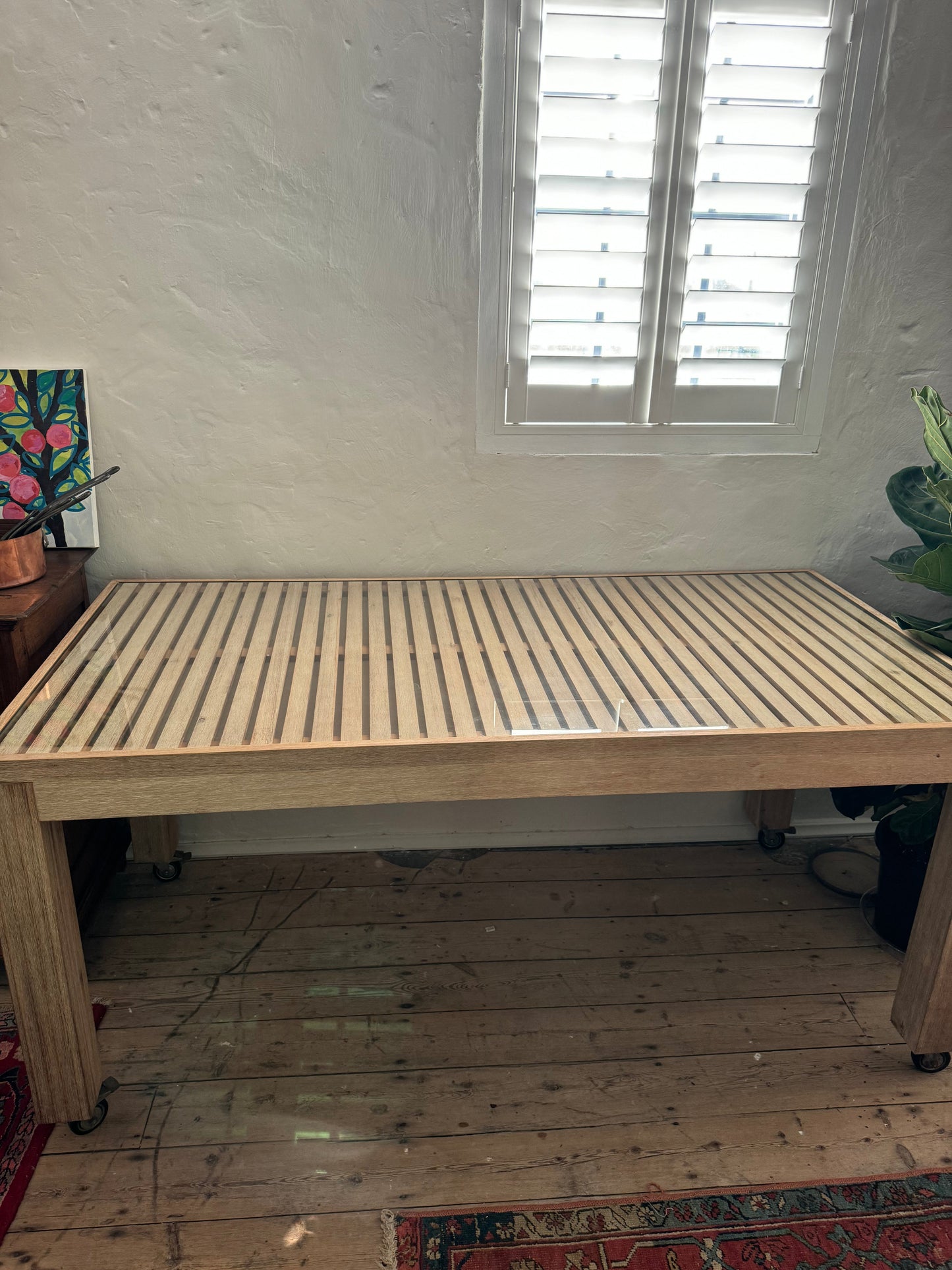 Glass topped table on castors