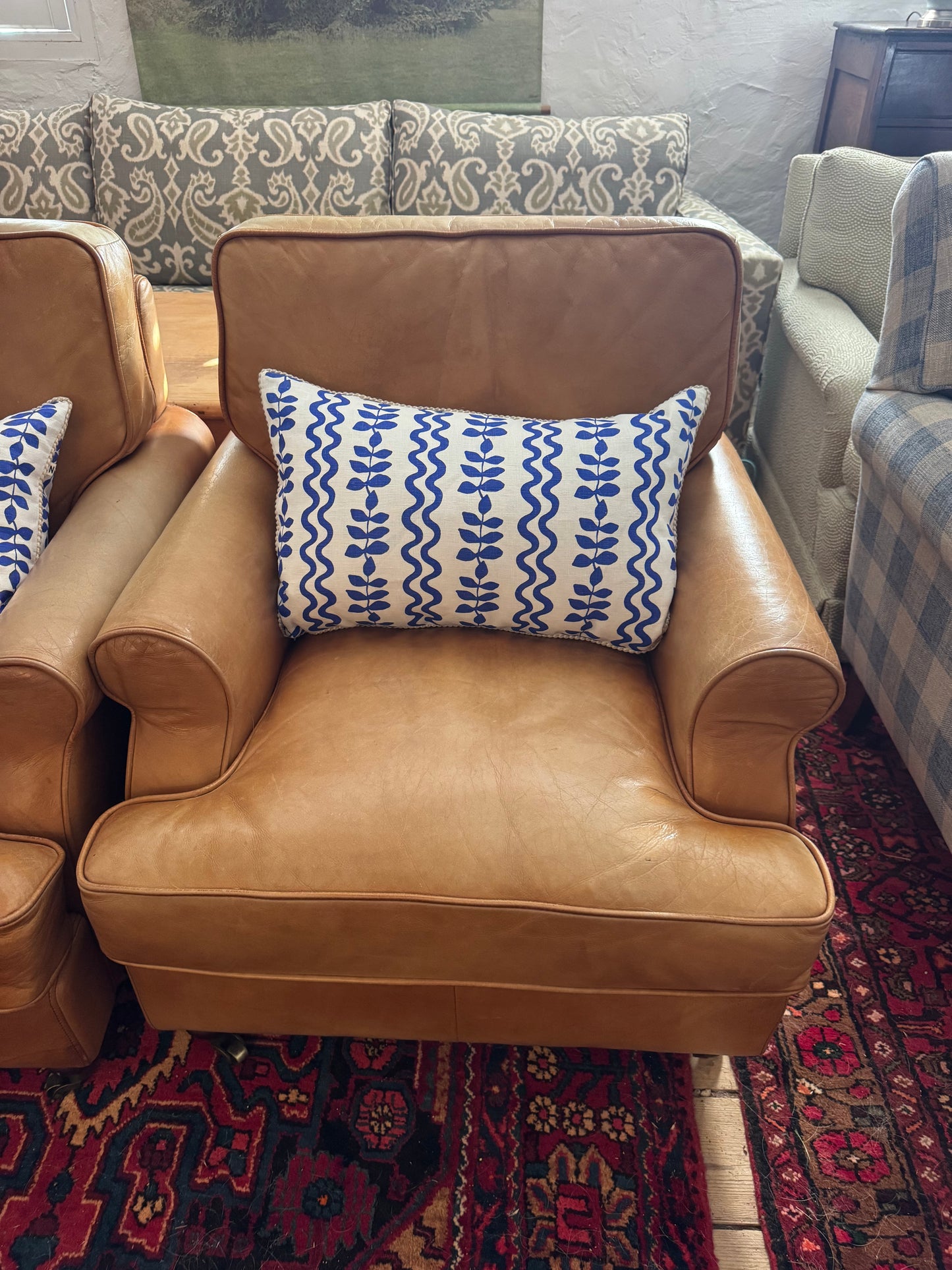 A pair of leather chairs on castors