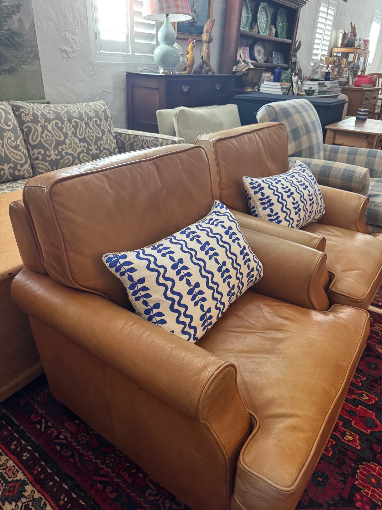 A pair of leather chairs on castors