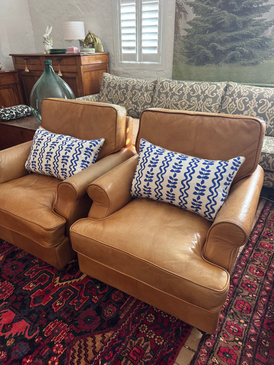 A pair of leather chairs on castors