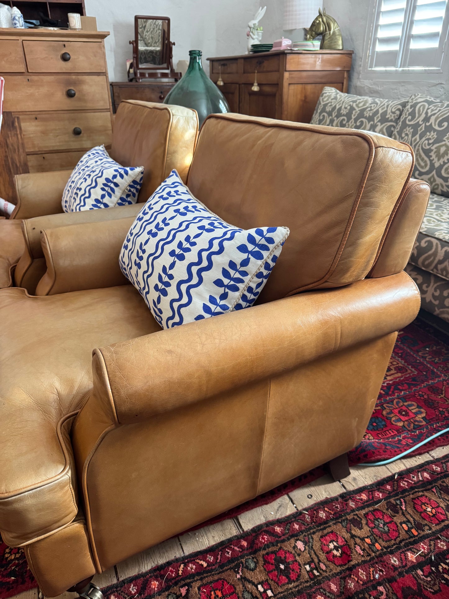 A pair of leather chairs on castors
