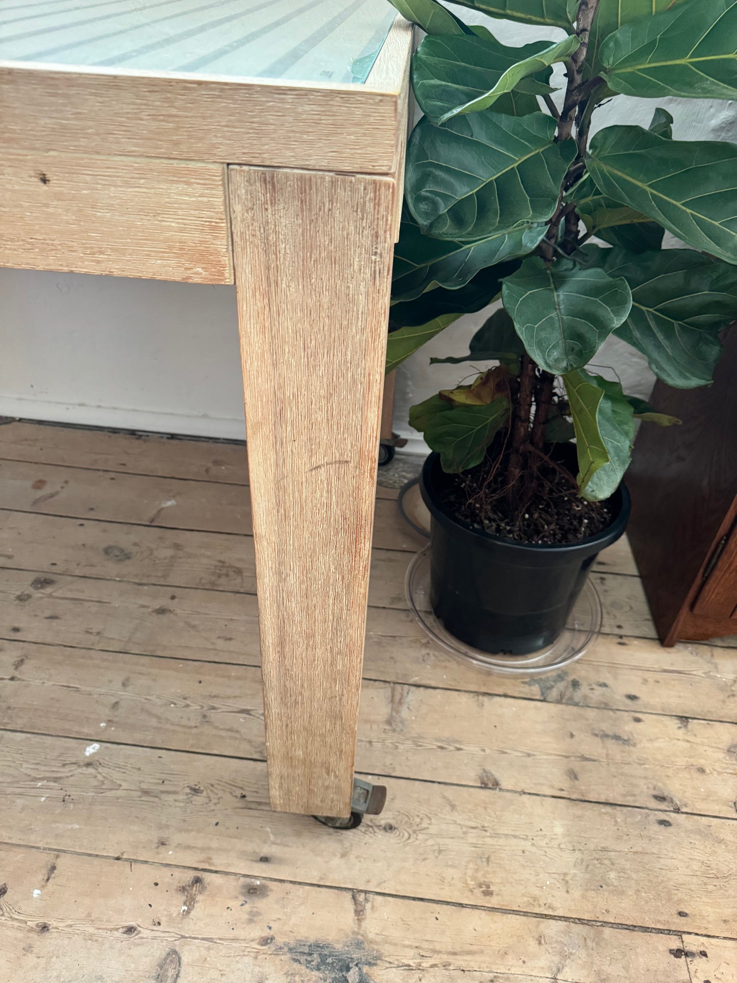 Glass topped table on castors