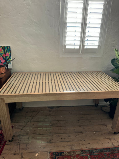 Glass topped table on castors