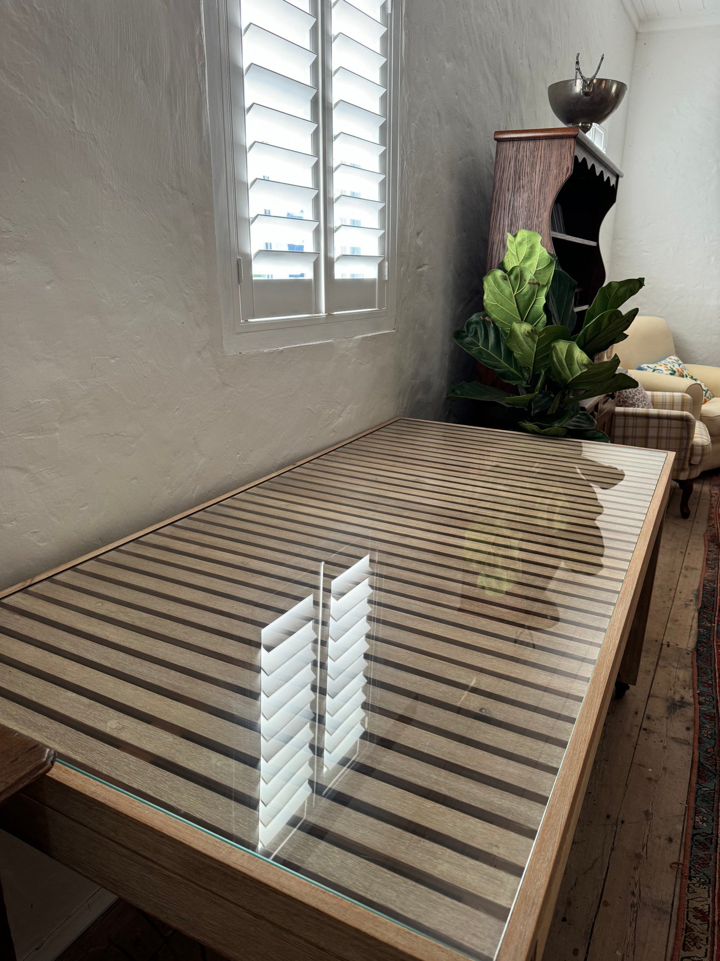 Glass topped table on castors